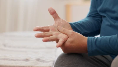 Close up of a man holding his hand with nerve pain.
