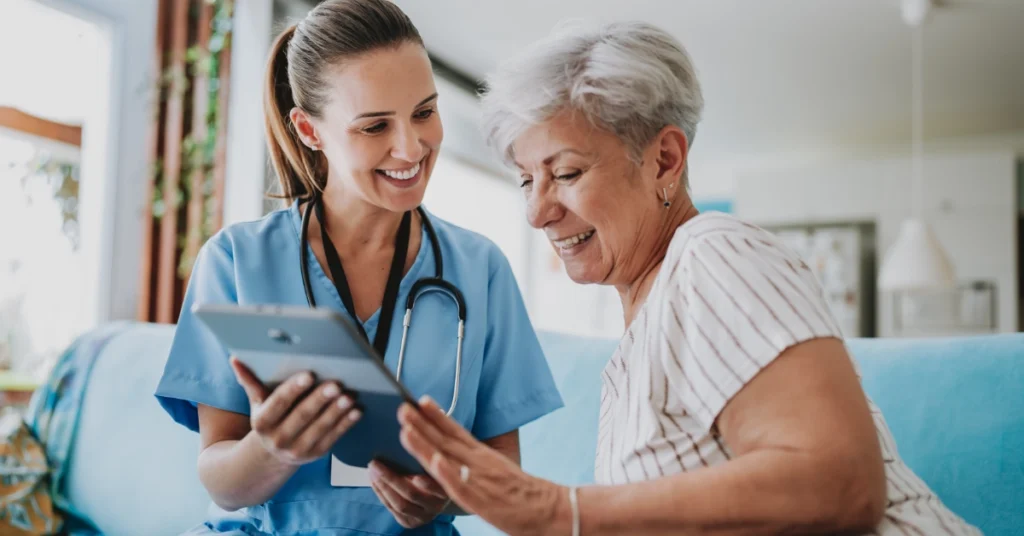 Smiling nurse reviewing treatment with patient.