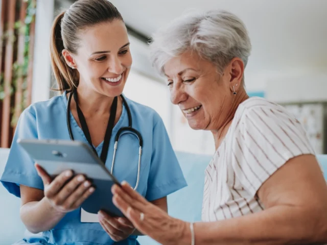 Smiling nurse reviewing treatment with patient.